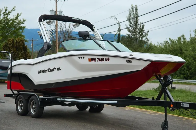 The Image of 2022 MasterCraft NXT22 boat on trailer, white and red. - 1