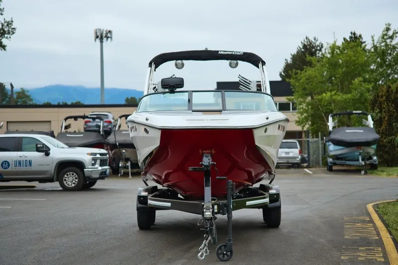 Slide: The Image of 2022 MasterCraft NXT22 boat parked on trailer outdoors. - 7