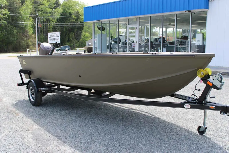 Slide: The Image of 2026 G3 Outfitter V187 T boat on trailer outside store. - 9