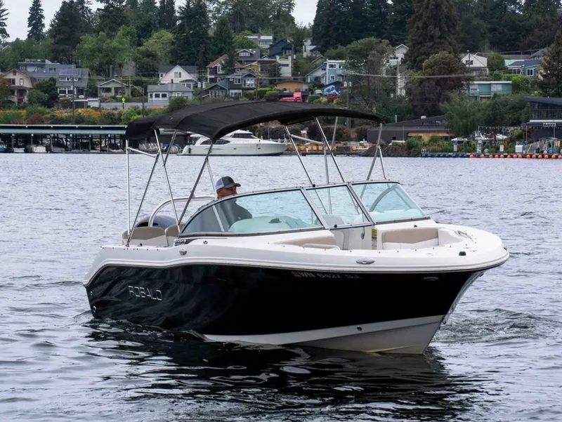 The Image of 2016 Robalo R207 Dual Console boat on a calm lake. - 1