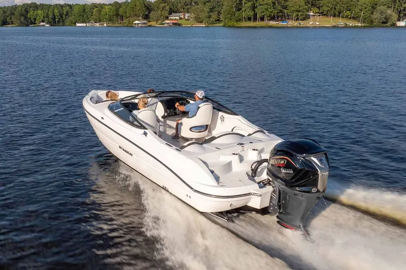 Slide: The Image of Stingray 23 OSX 2026 boat cruising on a serene lake. - 12