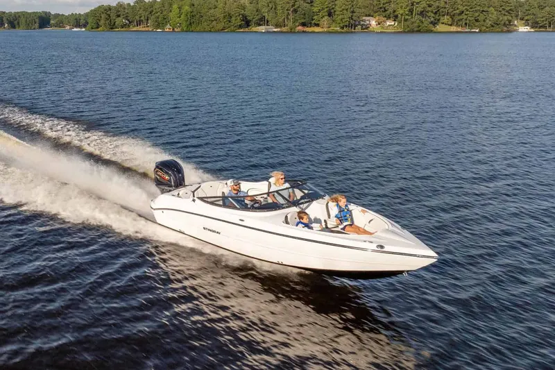 Slide: The Image of Stingray 23 OSX 2026 motorboat cruising on a serene lake. - 13