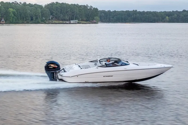 Slide: The Image of 2026 Stingray 23 OSX boat cruising on a serene lake. - 15