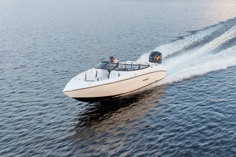 Slide: The Image of 2026 Stingray 23 OSX motorboat cruising on calm water. - 16