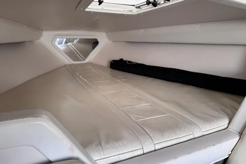 Slide: The Image of Interior cabin of a 2000 Fountain 27 Fever boat, featuring a cushioned sleeping area. - 31