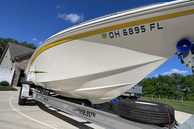 Slide: The Image of 2000 Fountain 27 Fever boat on Load Rite trailer, parked in driveway under blue sky. - 5