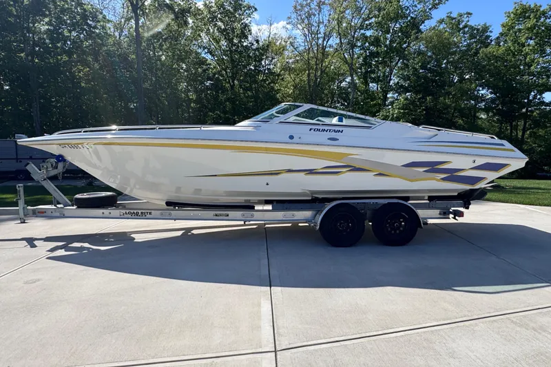 Slide: The Image of 2000 Fountain 27 Fever speedboat on trailer, parked outdoors, with vibrant graphics. - 9
