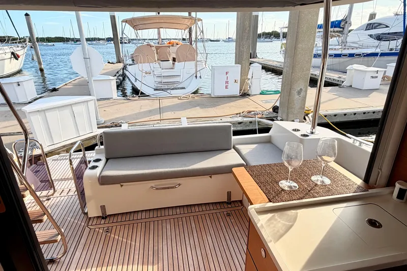 Slide: The Image of Beneteau Swift Trawler 41 Fly 2021 yacht interior with seating and wine glasses at marina. - 10