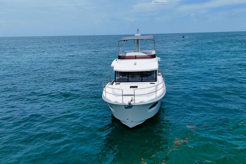 Slide: The Image of 2021 Beneteau Swift Trawler 41 Fly cruising on open sea under clear skies. - 2