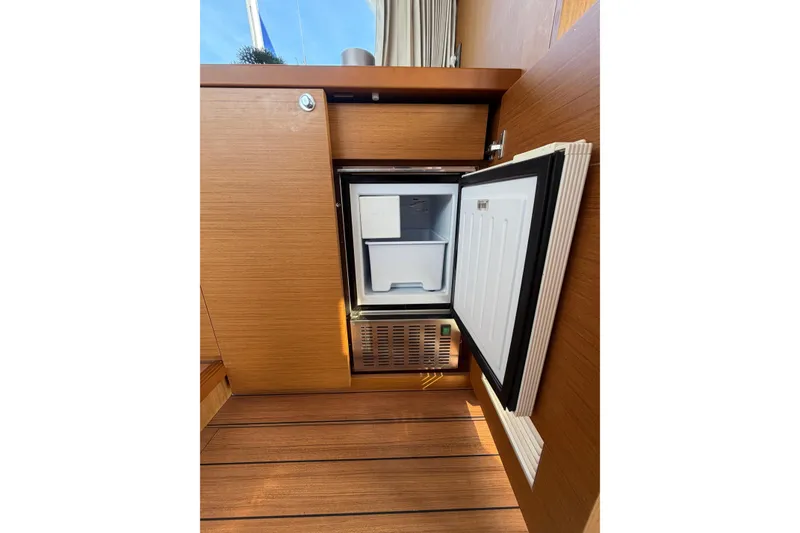 Slide: The Image of Open mini fridge on 2021 Beneteau Swift Trawler 41 Fly, showcasing interior storage space. - 31