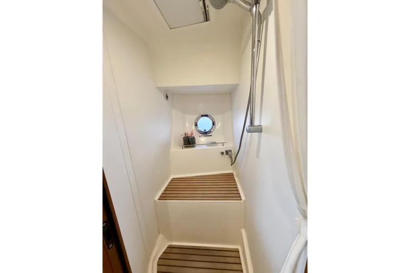 Slide: The Image of Shower area in 2021 Beneteau Swift Trawler 41 Fly with wooden flooring and porthole. - 43