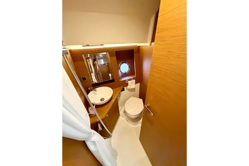 Slide: The Image of 2021 Beneteau Swift Trawler 41 Fly bathroom with modern fixtures and wooden accents. - 44