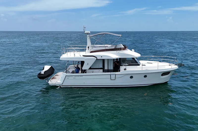 Slide: The Image of 2021 Beneteau Swift Trawler 41 Fly cruising on open sea under clear skies. - 6