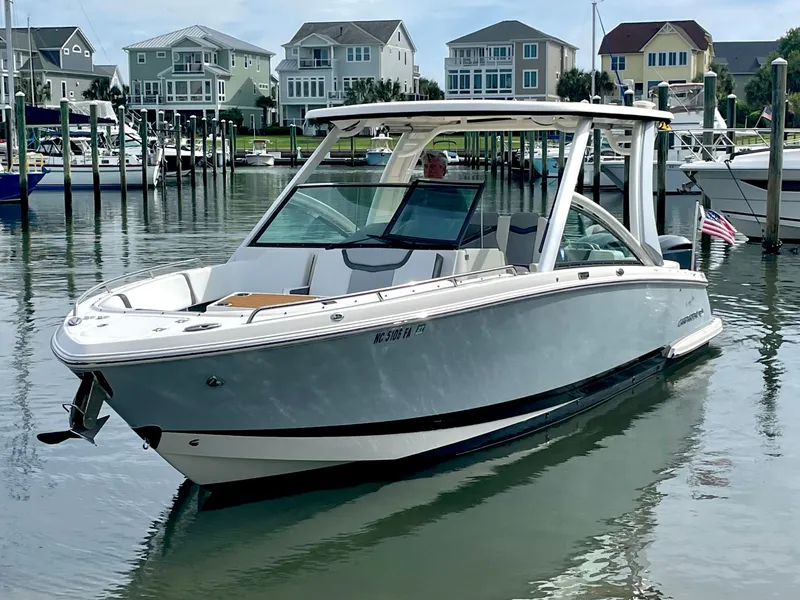 Slide: The Image of 2021 Chaparral 300 OSX boat in harbor, modern architecture in background. - 16