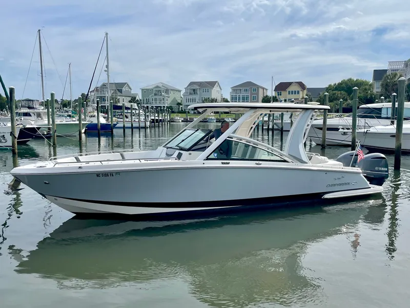 Slide: The Image of 2021 Chaparral 300 OSX boat docked in harbor, sleek design, calm waters. - 18