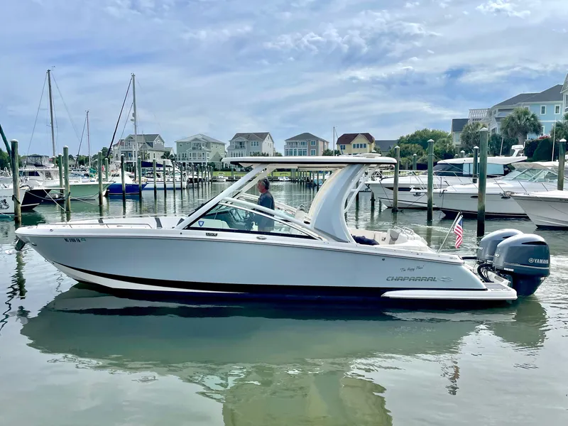 Slide: The Image of 2021 Chaparral 300 OSX boat docked in harbor, calm water, cloudy sky. - 19