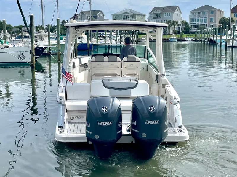 Slide: The Image of Chaparral 300 OSX 2021 boat in harbor with twin outboard engines. - 23