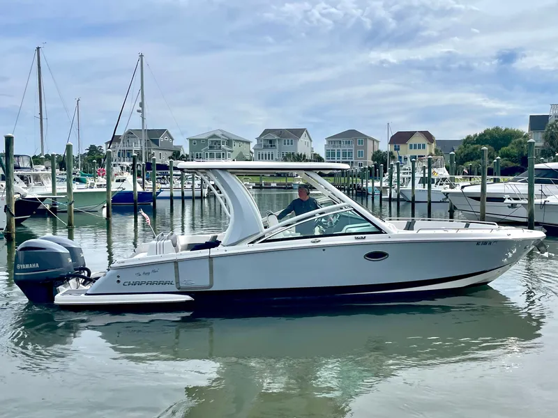 Slide: The Image of Chaparral 300 OSX 2021 boat docked in marina with houses in background. - 26
