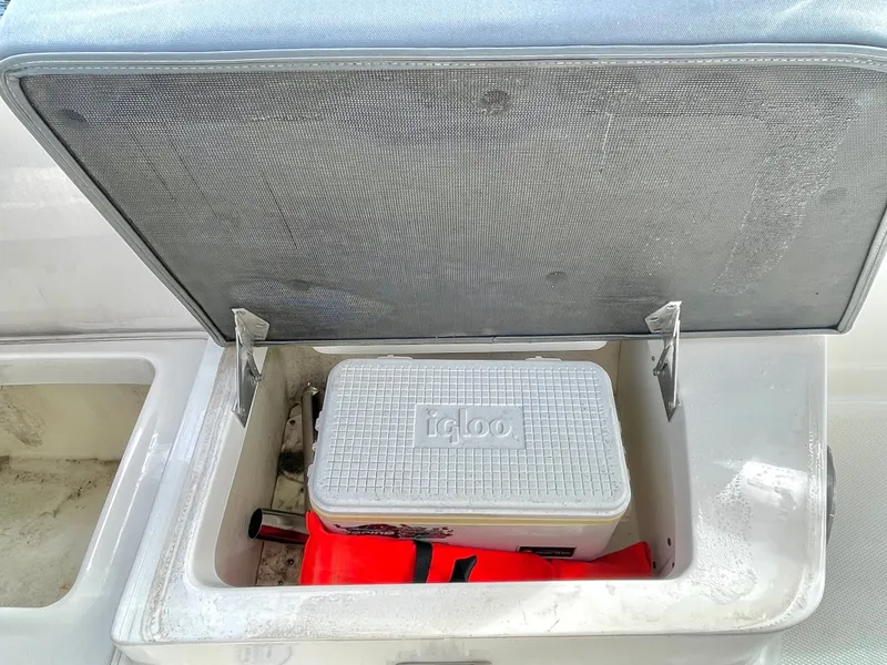 Slide: The Image of Open storage compartment in Chaparral 300 OSX boat with cooler and life jacket. - 46