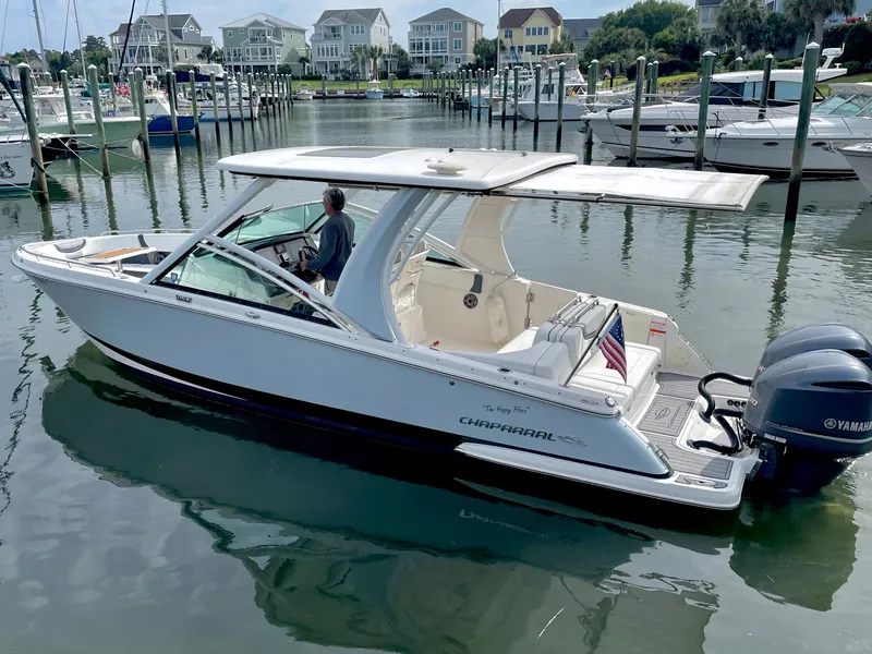 Slide: The Image of 2021 Chaparral 300 OSX boat docked in harbor with American flag. - 5