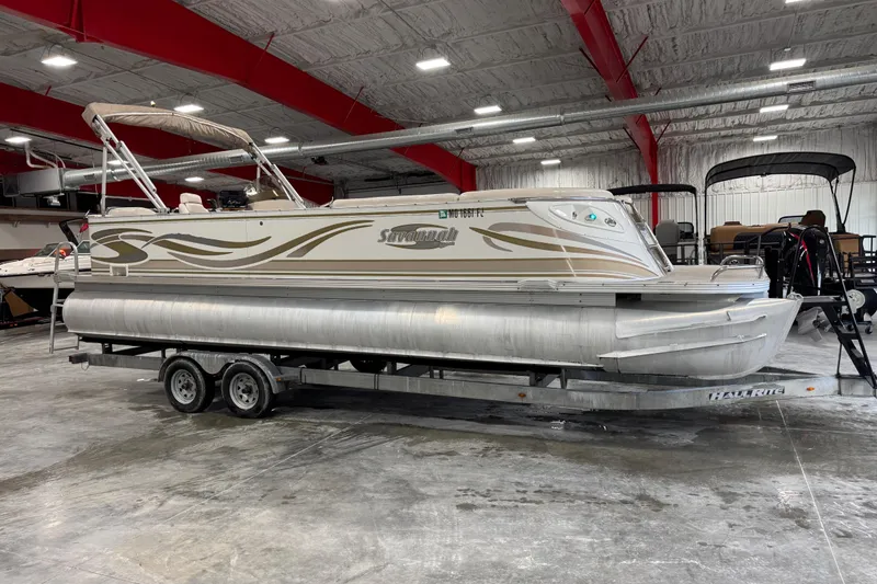 The Image of 2005 Crest 25 Savanna pontoon boat on trailer in indoor showroom. - 1