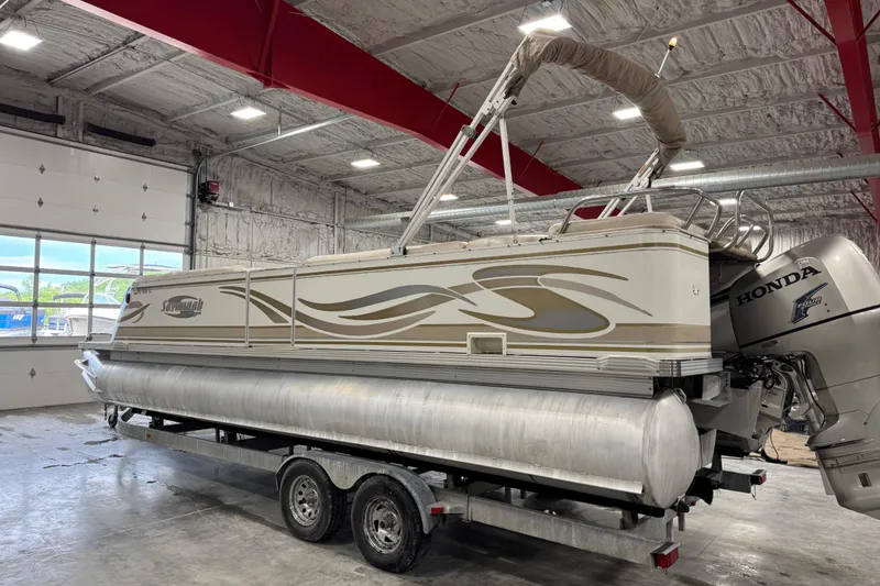 Slide: The Image of 2005 Crest 25 Savanna pontoon boat with Honda motor in indoor storage facility. - 3