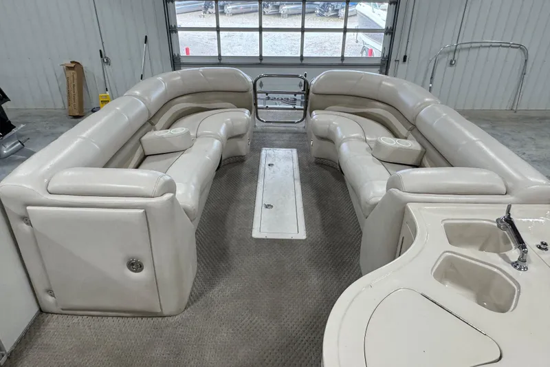 Slide: The Image of Interior of a 2005 Crest 25 Savanna pontoon boat with plush seating and a small sink. - 7