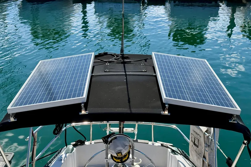 Slide: The Image of Catalina 38 sailboat with solar panels on deck, reflecting on calm water. - 10