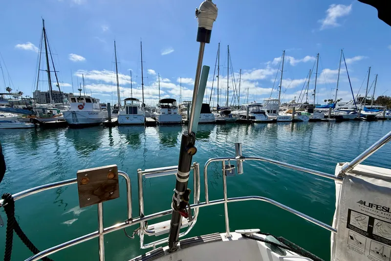 Slide: The Image of View from a 1985 Catalina 38 sailboat in a marina with docked boats. - 12