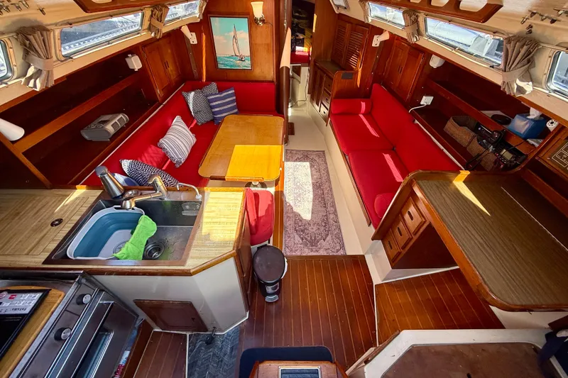 Slide: The Image of Interior of a 1985 Catalina 38 sailboat with red seating and wooden finishes. - 15
