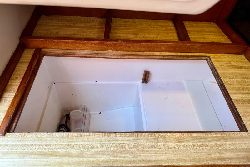 Slide: The Image of Interior storage compartment of a 1985 Catalina 38 sailboat, featuring wooden trim and clean design. - 18