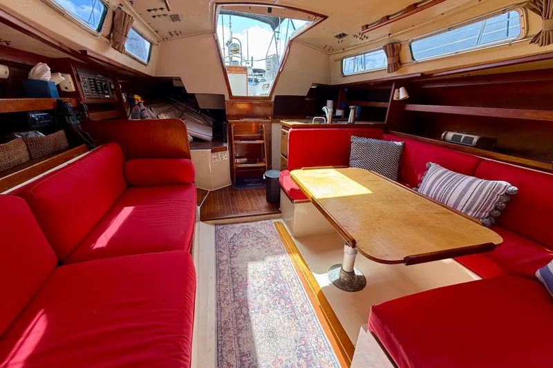 Slide: The Image of Interior of 1985 Catalina 38 sailboat with red seating and wooden table. - 28