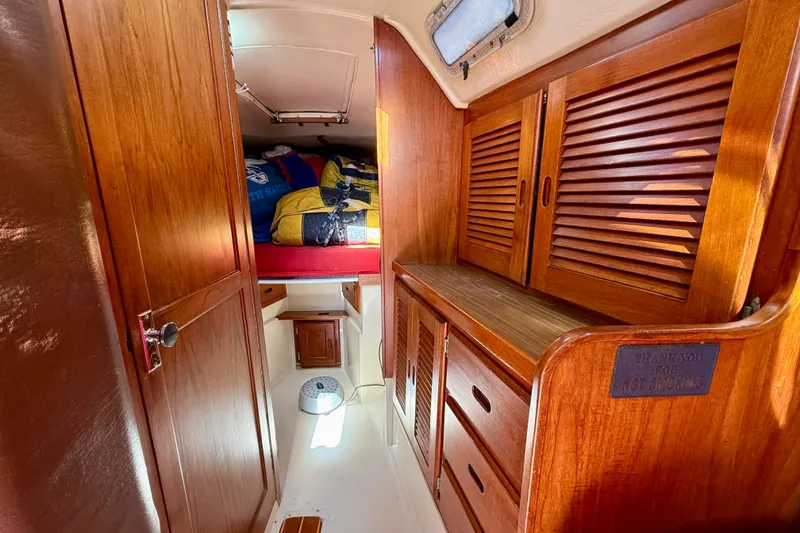 Slide: The Image of 1985 Catalina 38 sailboat interior with wooden cabinets and cozy sleeping area. - 29