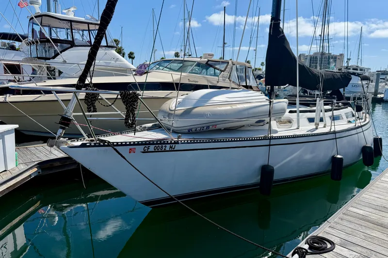 Slide: The Image of 1985 Catalina 38 sailboat docked at marina, surrounded by other boats. - 3