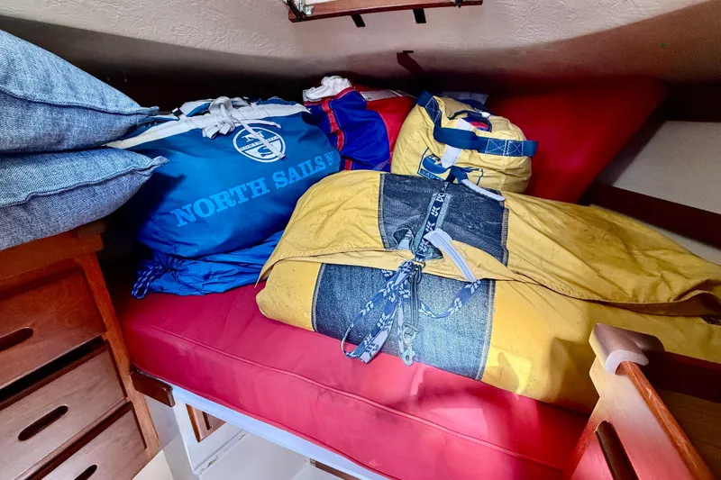 Slide: The Image of Interior of 1985 Catalina 38 sailboat with North Sails bags on red cushion. - 30