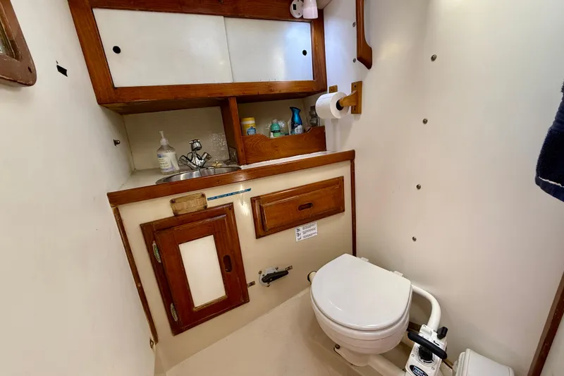Slide: The Image of Compact bathroom in a 1985 Catalina 38 sailboat with wooden cabinetry and marine toilet. - 31