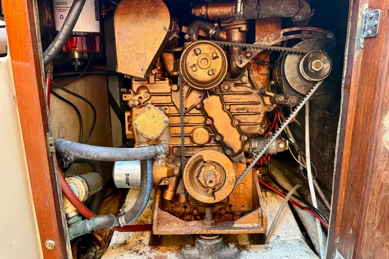 Slide: The Image of Engine compartment of a 1985 Catalina 38 sailboat, showcasing mechanical components and belts. - 33