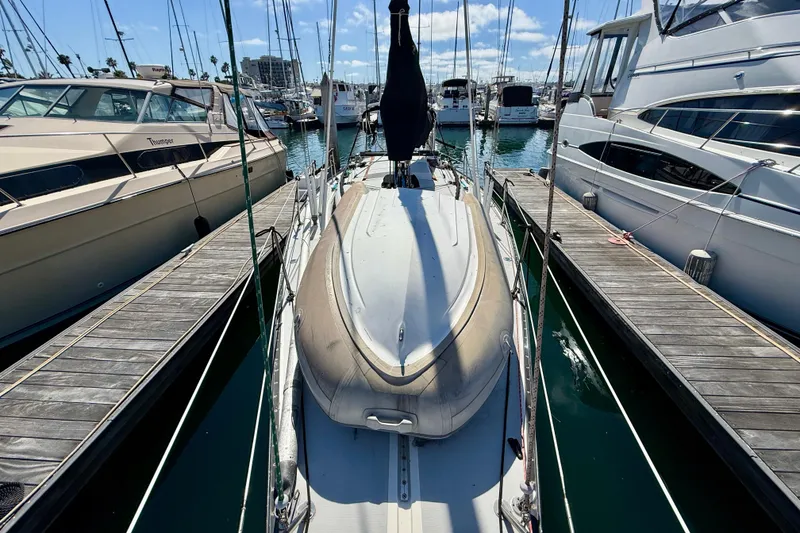 Slide: The Image of 1985 Catalina 38 sailboat docked at marina, surrounded by other boats under a clear sky. - 6