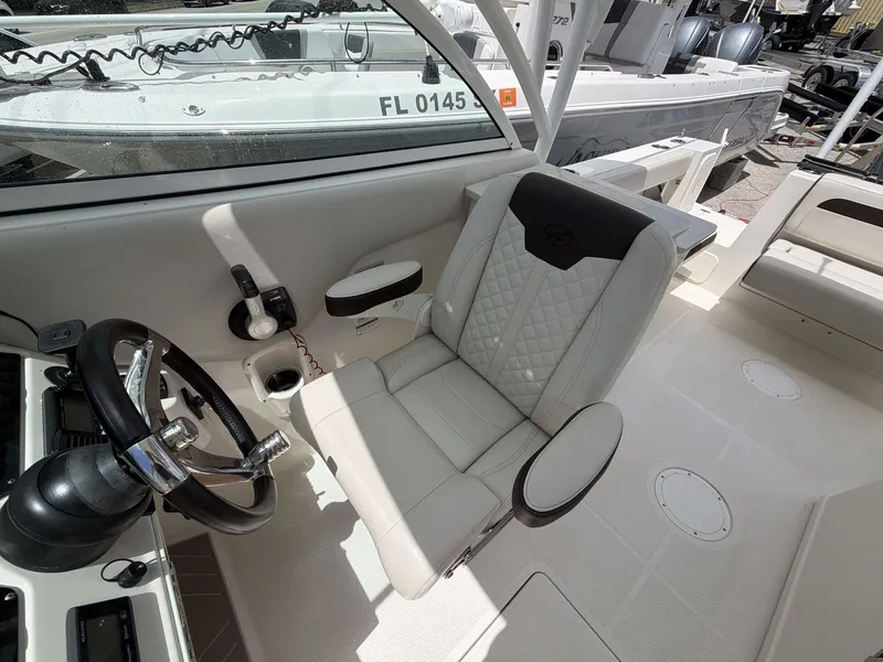 Slide: The Image of Interior of a 2022 Sailfish 245 DC boat with steering wheel and seat. - 16