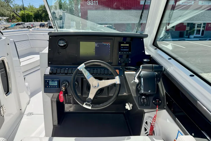 Slide: The Image of 2023 Blackfin 272 DC boat cockpit with steering wheel and navigation controls. - 12