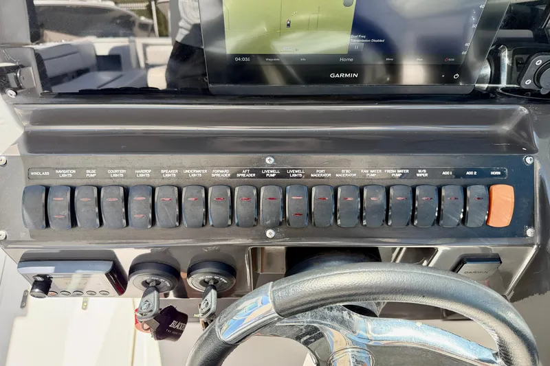 Slide: The Image of Control panel of 2023 Blackfin 272 DC boat with labeled switches and Garmin display. - 16