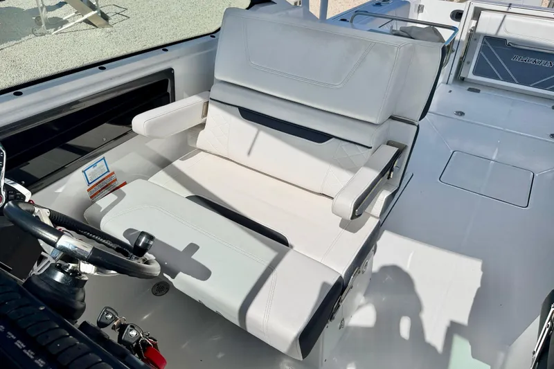 Slide: The Image of 2023 Blackfin 272 DC boat interior with white seating and steering wheel. - 21