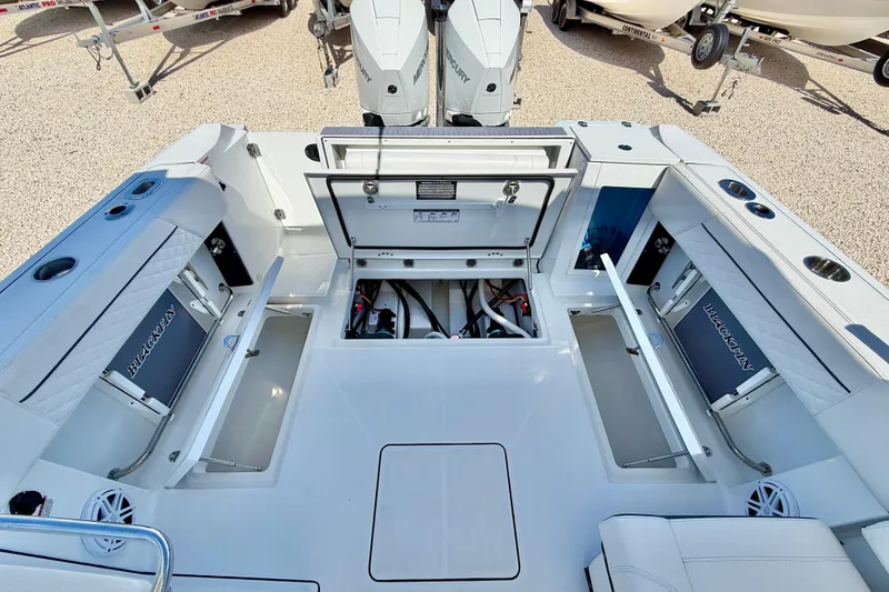 Slide: The Image of 2023 Blackfin 272 DC boat interior with open storage compartments and dual Mercury engines. - 25