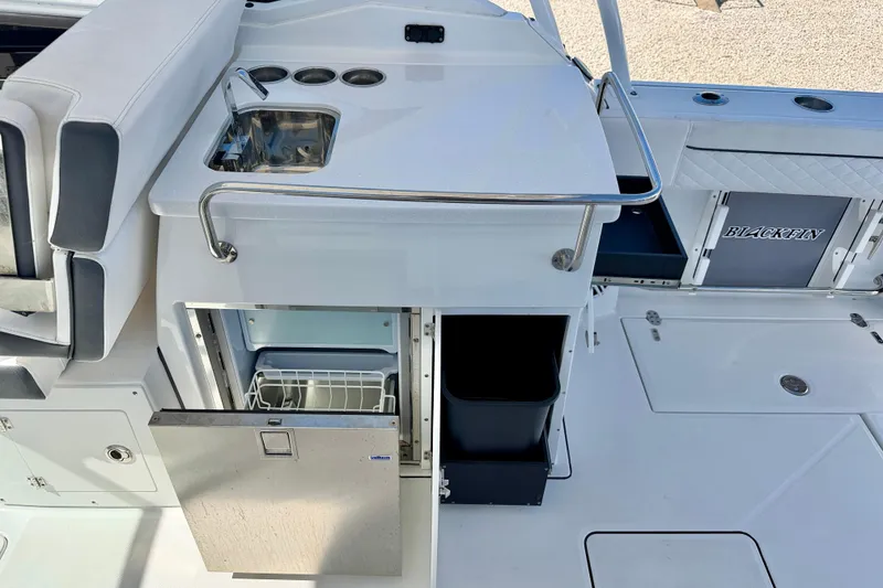 Slide: The Image of 2023 Blackfin 272 DC boat interior with sink, storage, and seating area. - 29