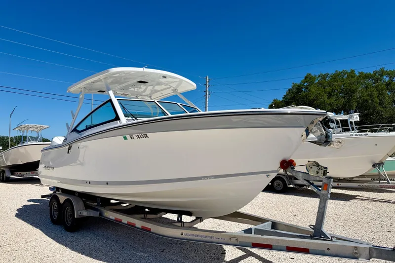 Slide: The Image of 2023 Blackfin 272 DC boat on trailer under clear blue sky. - 3