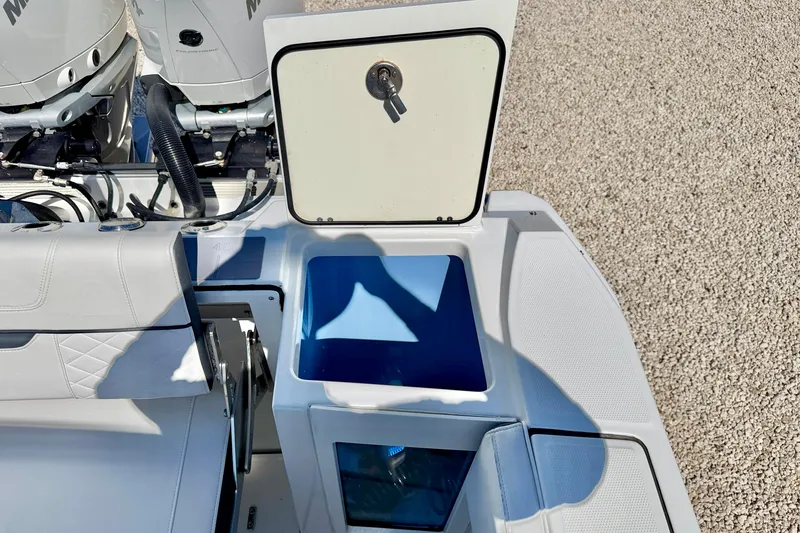Slide: The Image of 2023 Blackfin 272 DC boat with open storage compartment and visible engine components. - 34