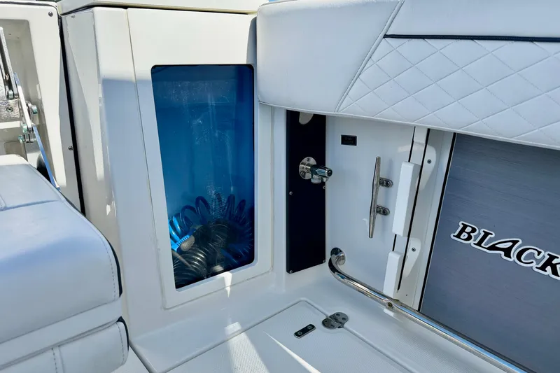 Slide: The Image of 2023 Blackfin 272 DC boat interior detail with storage compartment and logo. - 35