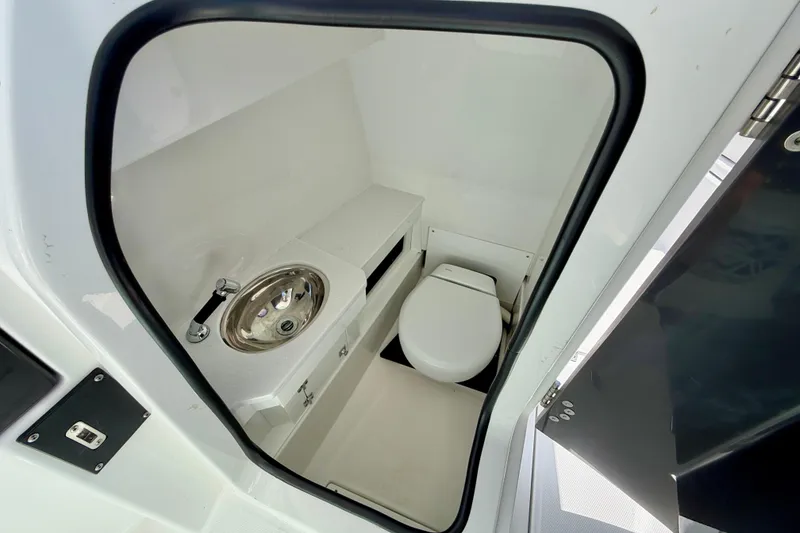 Slide: The Image of 2023 Blackfin 272 DC boat interior with compact bathroom, featuring a toilet and sink. - 37