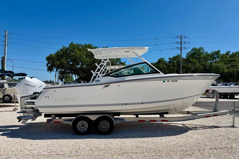 Slide: The Image of 2023 Blackfin 272 DC boat on trailer, featuring sleek design and Mercury outboard engine. - 4