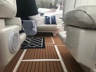 Slide: The Image of Interior of a 1999 Sea Ray Sundancer with wooden flooring and cushions. - 7